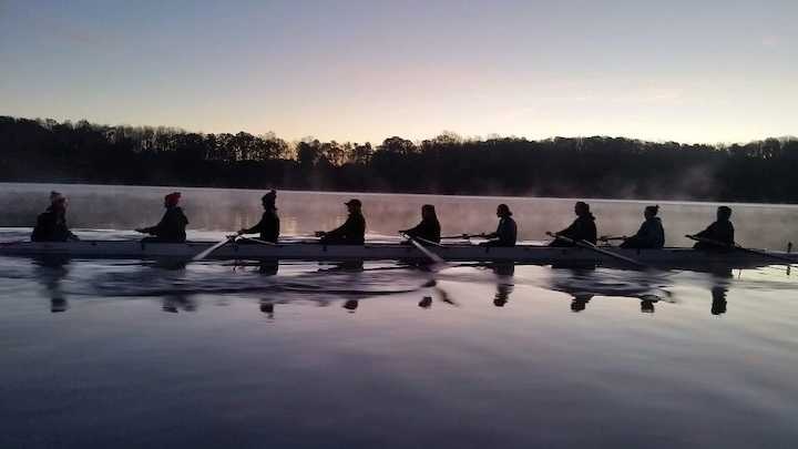 Virginia Tech crew team rowing on the water at dawn